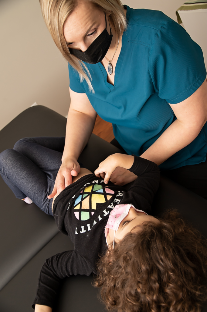 Manual Osteopathic Therapist treats child on treatment table